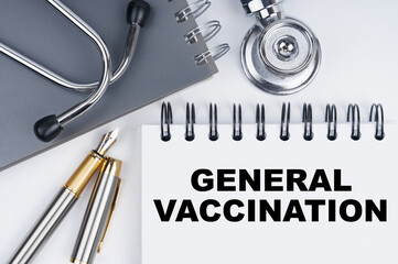 On the table are a stethoscope, a pen and a notebook with the inscription - GENERAL VACCINATION