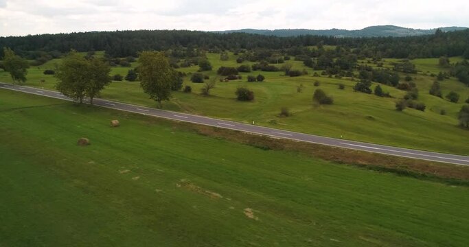 Aerial view of traffic on a road, in rural Slovenia - tracking, low, drone shot
