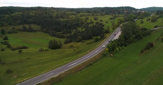 Aerial view of traffic on a rural road, in cloudy Slovenia - rising, drone shot