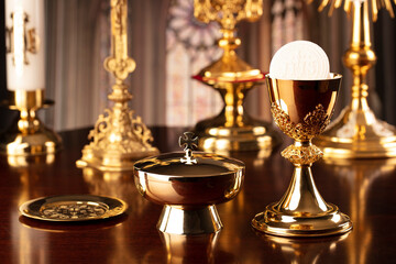 Fototapeta na wymiar First Holy Communion. Catholic religion theme. Crucifix, the Cross and Golden chalice and wafer on the altar in the church.