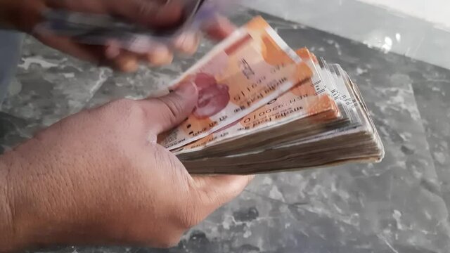 A man counts Indian new one hundreds of rupees, new two hundred of rupees, and new five hundred of rupee money notes 