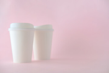 Blurred of White Paper Coffee Cup on Pink Background, Defocus Concept for Product Background.