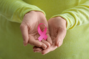 Woman with pink ribbon, closeup. Breast cancer awareness concept