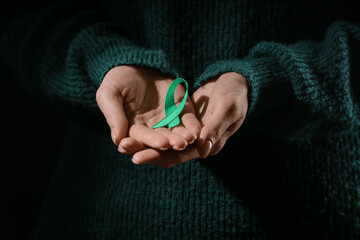 Woman with green ribbon, closeup. Mitochondrial diseases and kidney cancer concept
