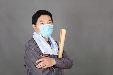 Male worker wearing mask holding drawings in hand