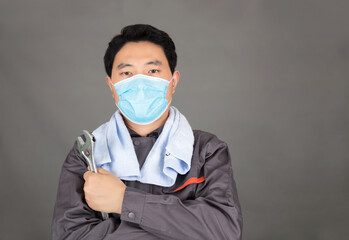 Worker with wrench tool in hand wearing mask