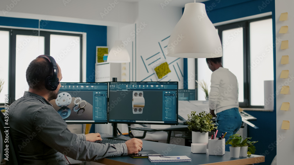 Wall mural mecanic technician working on cad software using computer with two monitors innovating an efficient 