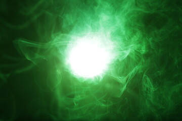 Fototapeta na wymiar Artificial magic smoke in green light on black background