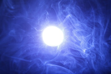 Fototapeta na wymiar Artificial magic smoke in blue light on black background