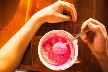 Male hands holding a spoon full of delicious pink smoothie bowl creamery paste. Perfect morning...