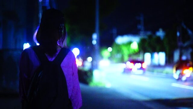 夜道を歩く女性の後ろ姿