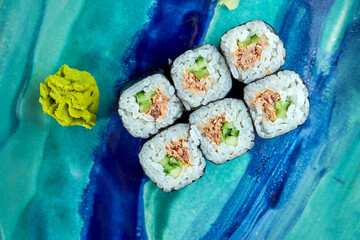 Appetizing Japanese sushi - maki with tuna served in a plate with ginger and wasabi on a black wood background. Japanese cuisine © ismishko