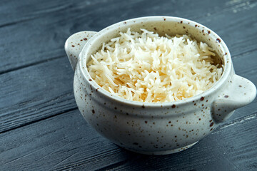 The classic side dish is saffron rice in a white bowl. Diet and vegetarian food. Dark wooden background