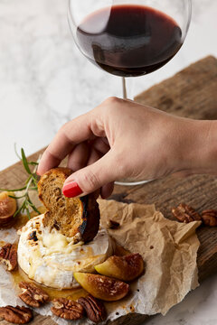 Baked brie with fresh figs and honey, served with glass of red wine