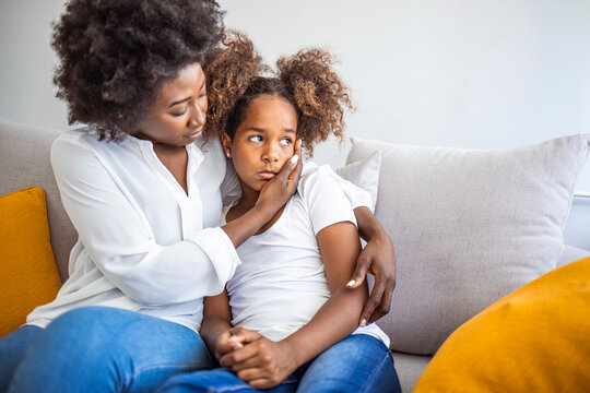 African American Mother Consoling Her Sad Girl At Home. Young Black Mother Taking Care Of Her Depressed Little Daughter At Home. Worried Young Foster Mother Comforting Embracing Adopted Child Daughter