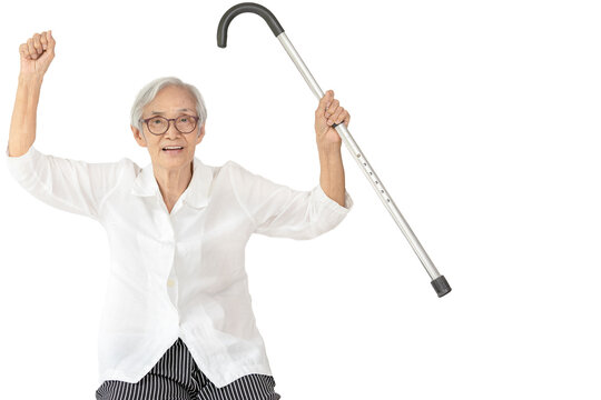 Healthy asian senior woman raise hand up with fist and raise walking stick,show a strong body,arm muscle power,physical strength,Happy smiling old elderly feel fit and good health,health care concept