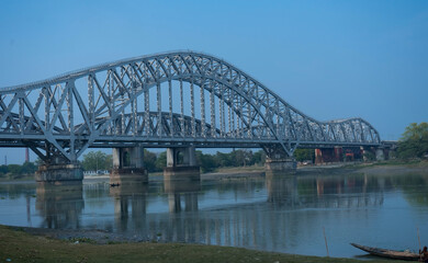 Fototapeta na wymiar A steel railway bridge over a clam river | Hooghly steel railway bridge named 'Sampreeti Bridge'