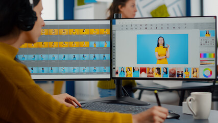 Professional photographer sitting at desk putting on headphones for listening music using PC in photo studio retouches. Content creator doing portrait retouching using post production software © DC Studio