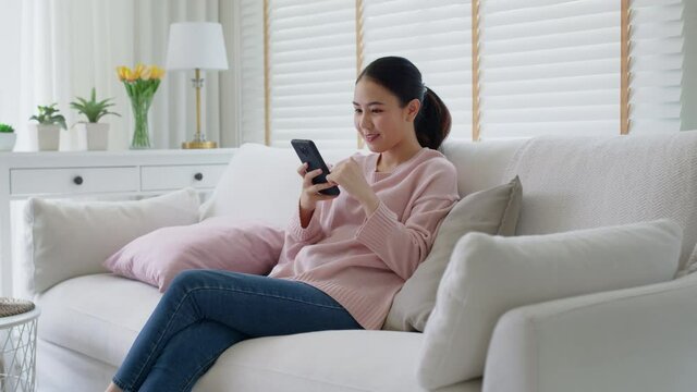 Young asia people 5G wifi digital device user teen girl watch read news play social media, e-commerce iot data app, pay money, remote shop retail store at home sofa couch sit easy relax happy smile.