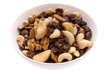 a mixture of chopped dried fruits and berries, nuts in a white dish on a white background.Isolated Products and items