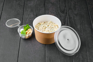 Bulgur porridge with nuts and cranberries in sugar pouder breading in take away packaging