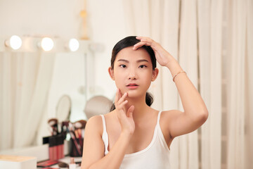 Naklejka premium Perfect Skin. Cheerful Brunette Woman Touching Face Looking In Mirror