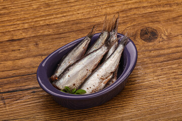 Anchovies in the bowl served basil leaves