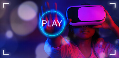 Asian child girl wearing VR glasses Playing games or watching videos in the dark with blue and red lights