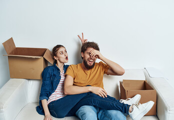 Young family sitting on couch boxes with stuff moving fun