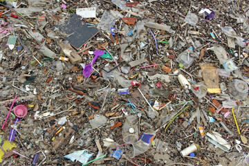 Above view of a beach polluted by a complete covering of plastic waste and other garbage dumped by people and washed up on the shore