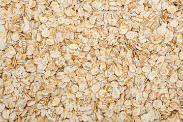 Oat flakes background. Dry uncooked whole grain oats top view.