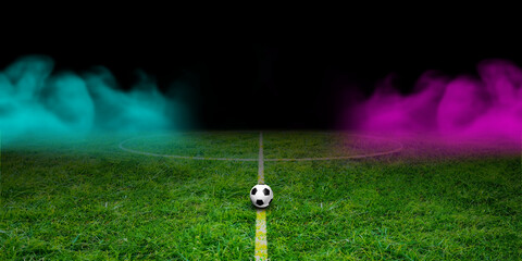 Soccer ball on the green field in football stadium. with Neon Smoke at night.  midfield playground view, panorama 