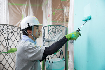 真剣に仕事する若い日本人の塗装業、仕事中の横顔