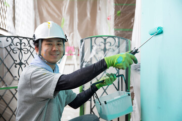 笑顔の若い日本人の塗装業、視線有、仕事中の横顔