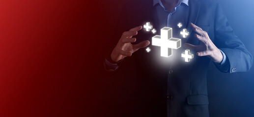 Businessman hold 3D plus icon, man hold in hand offer positive thing such as profit, benefits, development, CSR represented by plus sign.The hand shows the plus sign