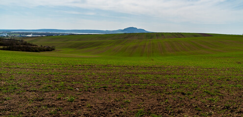 Fototapeta na wymiar Rolling landscape with field, Nove Mlyny water reservoir and Palava mountains on the background in Czech republic