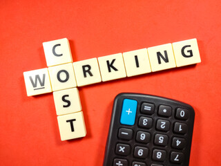 Selective focus.Scrabble letters with text COST WORKING and calculator on red background.