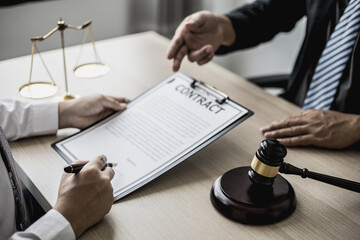 The lawyer explains the contract before allowing the client to sign the lawsuit admitting that the defendant is a business partner who has opened a company and has cheated. Asset embezzlement concept.