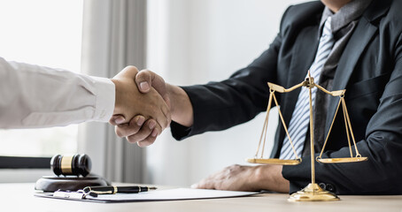 Lawyer and client shake hands, after winning a lawsuit where a lawyer hired by a client in a fraud...