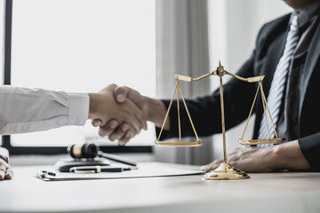 Lawyer and client shake hands, after winning a lawsuit where a lawyer hired by a client in a fraud...