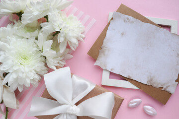 postcard mockup. small bouquet of white chrysanthemums, envelope, white blank for text and pearl beads 