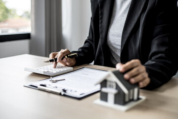 Employees use the calculator to calculate monthly rent for tenants and explain renting details and calculate monthly rent payments to tenants before signing the contract. Renting a house concept.