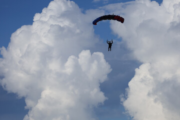 Skydiving. Cloudy sky and a parachute in the sky.