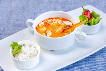 Tom yam shrimp soup beautifully served in a white bowl in the restaurant. Restaurant menu concept