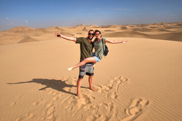 happy couple enjoying adventure travel through namib desert