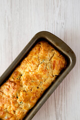 Homemade Cheesy Bread Loaf on a white wooden background, top view. Copy space.