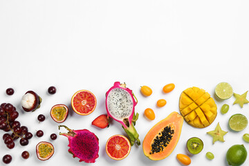 Many different delicious exotic fruits on white background, flat lay. Space for text