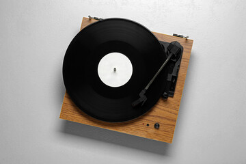 Turntable with vinyl record on white background, top view