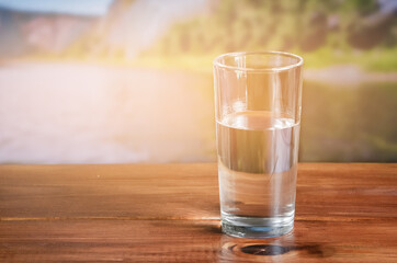 water in a glass on a wooden table outdoors