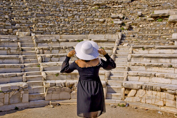 Beautiful young woman in black dress in Ephesus ancient city